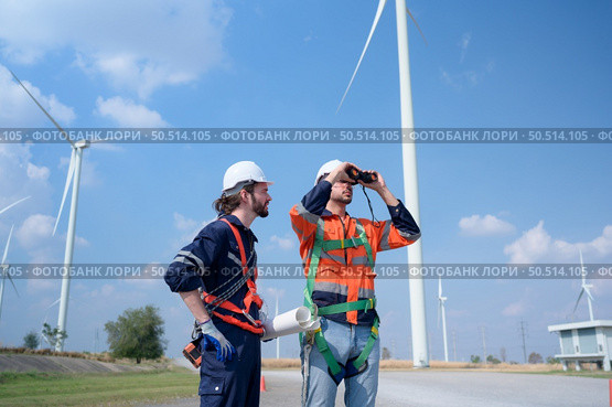 Surveyor and engineer Examine the efficiency of gigantic wind turbines that transform wind energy into electrical energy that is then used in daily life. Стоковое фото, агентство Ingram Publishing / Фотобанк Лори