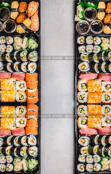 Sushi sets assortment in bento boxes on gray stone background, top view, vertical border.  Japanese and Asian food. Стоковое фото, агентство Ingram Publishing / Фотобанк Лори