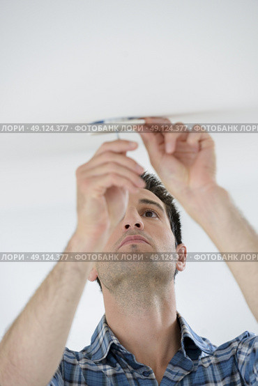 Swapping out a broken bulb. Стоковое фото, агентство Ingram Publishing / Фотобанк Лори
