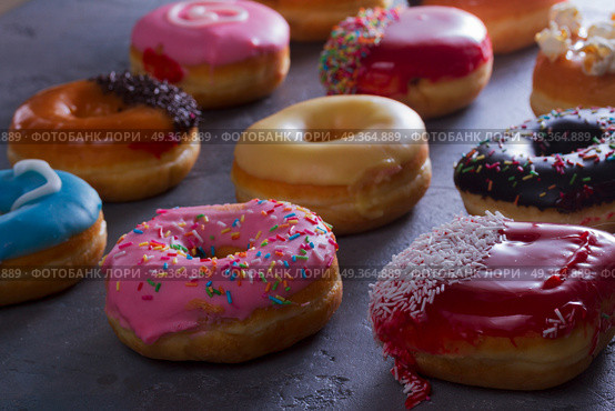 sweet doughnuts on gray stone background. sweet doughnuts on gray stone background, low key scene. Стоковое фото, агентство Ingram Publishing / Фотобанк Лори