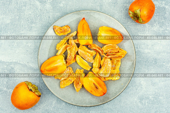 Sweet dried persimmon on the plate. Healthy vegan snacks. Tasty dried persimmon, healthy snacks. Стоковое фото, агентство Ingram Publishing / Фотобанк Лори