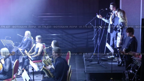 Symphony orchestra concert in mysterious darkness under stage spotlights. The conductor controls the orchestra. Редакционное видео, видеограф Евгений Ткачёв / Фотобанк Лори