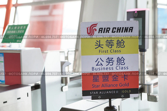 Табличка компании Air China с надписями для пассажиров первого класса, бизнес класса и со статусом Star Alliance Gold. Ухань, Китай (2024 год). Редакционное фото, фотограф Кекяляйнен Андрей / Фотобанк Лори