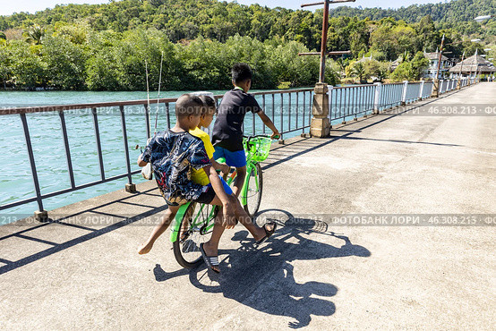Таиланд. Ко Чанг. Дети едут на велосипеде после рыбалки. Thailand. Koh Chang. Children ride a bike after fishing. Стоковое фото, фотограф Алексей Смышляев / Фотобанк Лори