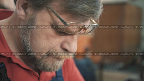 Tailor in a sewing workshop sews with a needle and thread. Close-up shot. Стоковое видео, видеограф EStarodubov / Фотобанк Лори