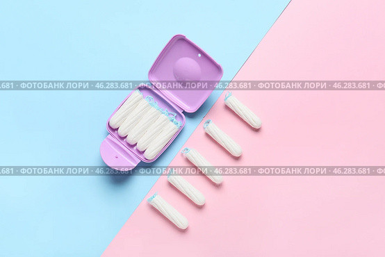Tampons storage box and tampons on pink and blue background, top view. Стоковое фото, фотограф Pixel_shot / Фотобанк Лори