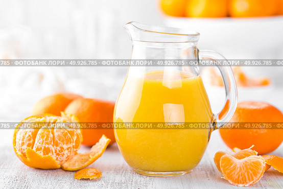 Tangerines, peeled tangerines and tangerine juice in glass. Mandarine juice. Стоковое фото, агентство Ingram Publishing / Фотобанк Лори