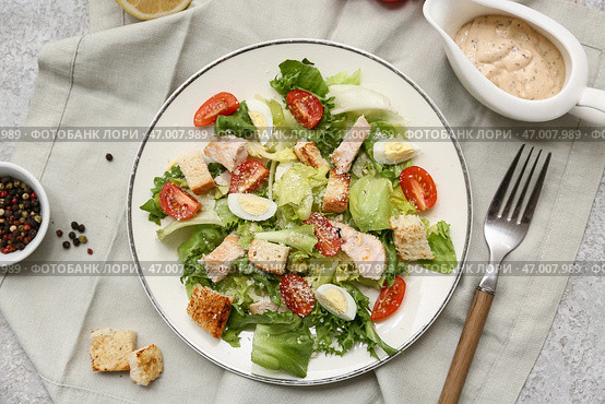 Тарелка с вкусным салатом Цезарь с курицей, перечницей и соусником на сером фоне. Стоковое фото, фотограф Pixel_shot / Фотобанк Лори