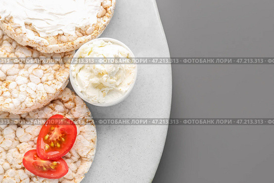 Тарелка с вкусными хрустящими хлебцами и сливочным сыром на сером фоне, крупным планом. Стоковое фото, фотограф Pixel_shot / Фотобанк Лори