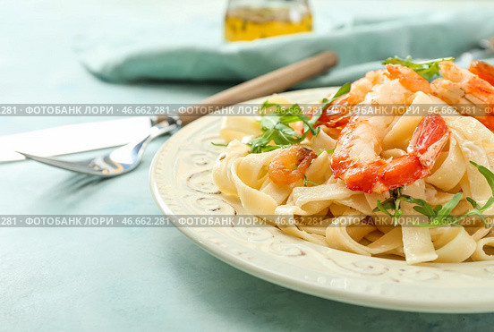Тарелка с вкусными креветками и пастой на столе. Стоковое фото, фотограф Pixel_shot / Фотобанк Лори