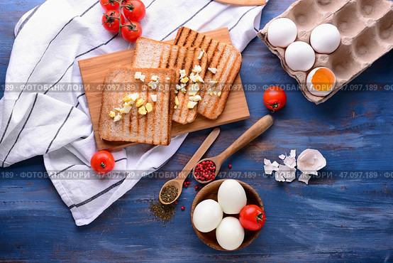 Тарелка с вкусными вареными яйцами и поджаренным хлебом со специями на цветной деревянный стол. Стоковое фото, фотограф Pixel_shot / Фотобанк Лори