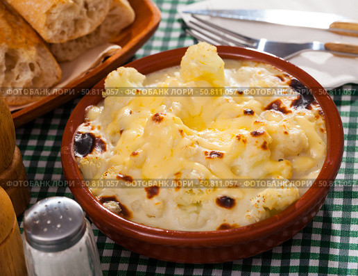 Tasty baked cauliflower with bechamel sauce in clay pot at table. Стоковое фото, фотограф Яков Филимонов / Фотобанк Лори
