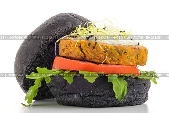 Tasty grilled veggie burger with chickpeas and vegetables on black bread on white background. Стоковое фото, агентство Ingram Publishing / Фотобанк Лори