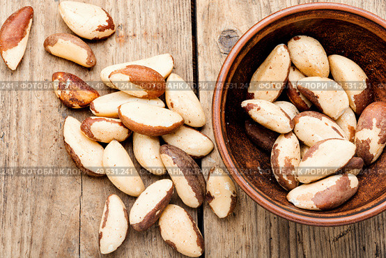Tasty peeled brazil nut in bowl on old wooden table. Brazil nut or Bertholletia. Стоковое фото, агентство Ingram Publishing / Фотобанк Лори