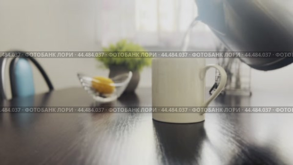 Tea is brewed in a white mug on the kitchen table in the early morning. Стоковое видео, видеограф Ярославский Максим / Фотобанк Лори