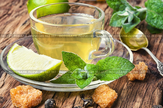 Tea with mint and lemon. Glass cup with tea with lemon and mint on a saucer. Стоковое фото, агентство Ingram Publishing / Фотобанк Лори