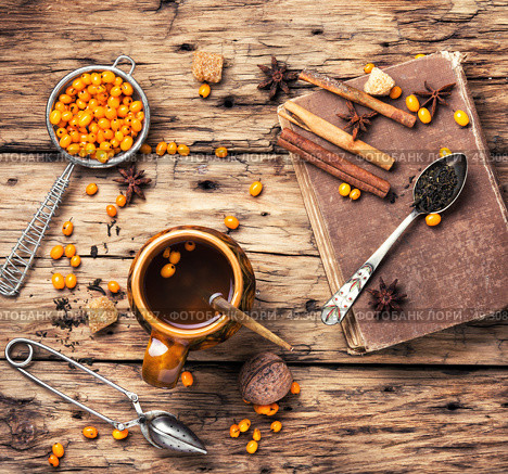 tea with sea-buckthorn. cup with healing tea with berries of sea-buckthorn on wooden retro background. Стоковое фото, агентство Ingram Publishing / Фотобанк Лори