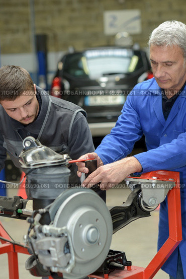 teacher helping students training to be car mechanics. Стоковое фото, агентство Ingram Publishing / Фотобанк Лори