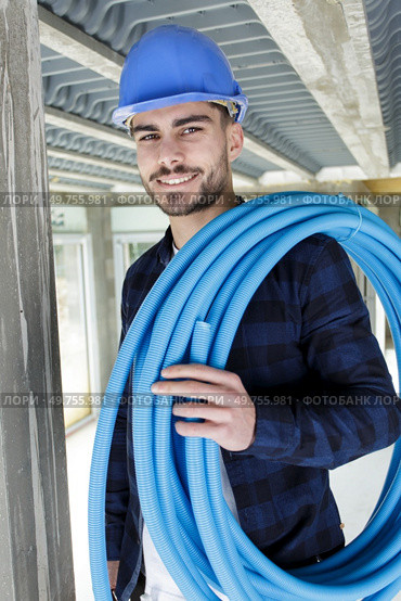 technician holding water pipes indoors. Стоковое фото, агентство Ingram Publishing / Фотобанк Лори