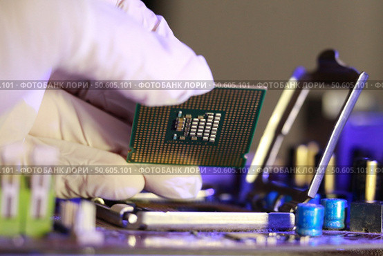 Technician installing CPU chip microprocessor socket on motherboard. Стоковое фото, агентство Ingram Publishing / Фотобанк Лори