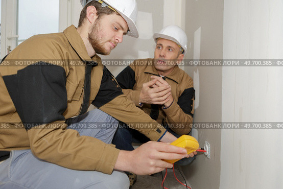 technician metering socket voltage with digital multimeter. Стоковое фото, агентство Ingram Publishing / Фотобанк Лори
