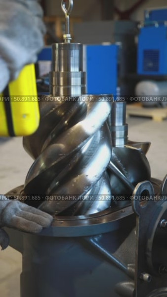 Technician placing screw compressor rotor into housing. Стоковое видео, видеограф Юрий Поздников / Фотобанк Лори