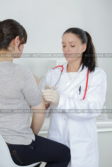 teen girl complaining to mature doctor about symptoms of malaise. Стоковое фото, агентство Ingram Publishing / Фотобанк Лори