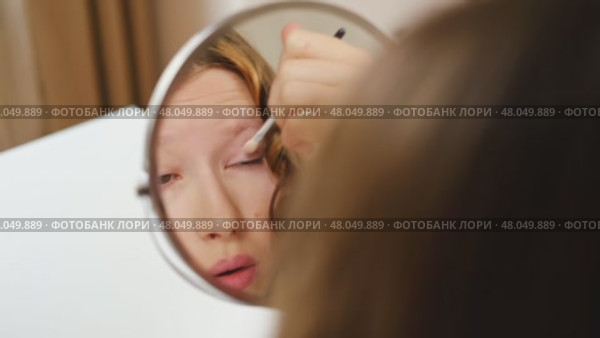 Teen Girl putting on makeup looking at mirror. Beautiful Teenager caring her face. 14 years old female applied cosmetics. Natural beauty concept. Skin care, make-up. Daily make up. Beautiful Teenage. Стоковое видео, видеограф Марина Демидюк / Фотобанк Лори