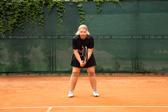Teenage Girl Perfecting Her Serve on an Outdoor Tennis Court During Afternoon Practice. Стоковое фото, фотограф Aleksandr Golubev / Фотобанк Лори
