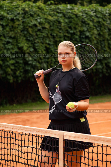 Teenage Girl Showcases Determination While Training on a Vibrant Outdoor Tennis Court. Стоковое фото, фотограф Aleksandr Golubev / Фотобанк Лори