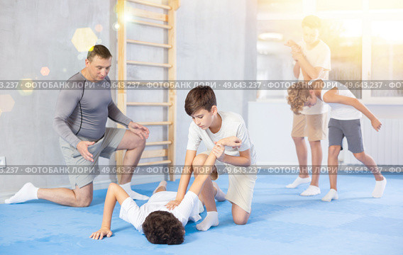 Teenager applying armlock technique to face-down opponent at self-defense classes. Стоковое фото, фотограф Яков Филимонов / Фотобанк Лори