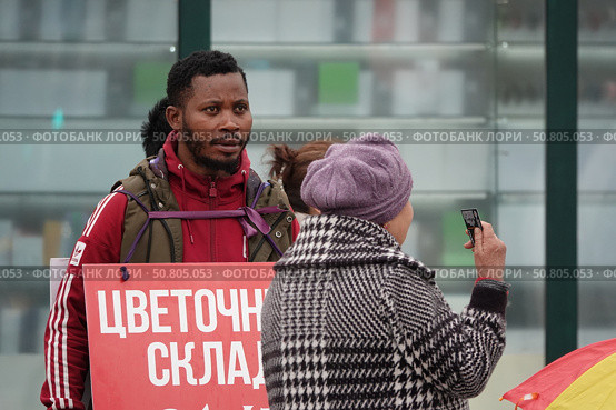Темнокожий мужчина подрабатывает живой рекламой на улице Москвы (2022 год). Редакционное фото, фотограф Free Wind / Фотобанк Лори