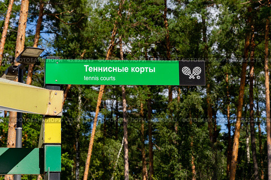 Теннисные корты. Указатель дорожного знака, указывающий на место, где находятся теннисные корты. Вход на открытый теннисный корт в общественном городском парке. Стоковое фото, фотограф Ирина Михайличенко / Фотобанк Лори