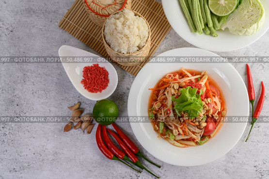 Thai papaya salad in a white plate with Sticky rice in wicker basket bamboo and dried shrimp. Стоковое фото, агентство Ingram Publishing / Фотобанк Лори