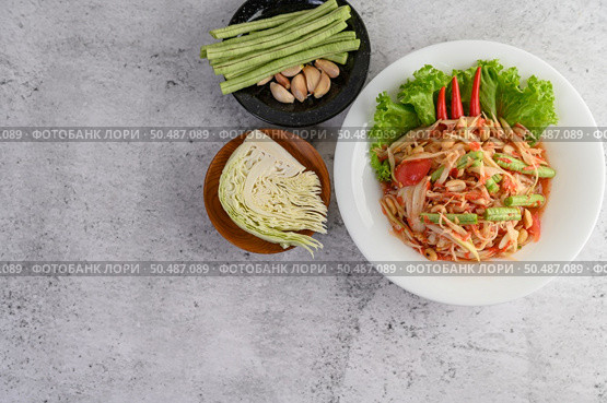 Thai papaya salad in a white plate with Yardlong beans, garlic, and Collard white. Top view. Стоковое фото, агентство Ingram Publishing / Фотобанк Лори