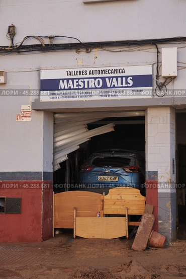 The aftermath of hurricane Dana in Valencia, Spain - Devastating flood damages car and furniture in Valencia garage. Стоковое фото, фотограф Данил Руденко / Фотобанк Лори