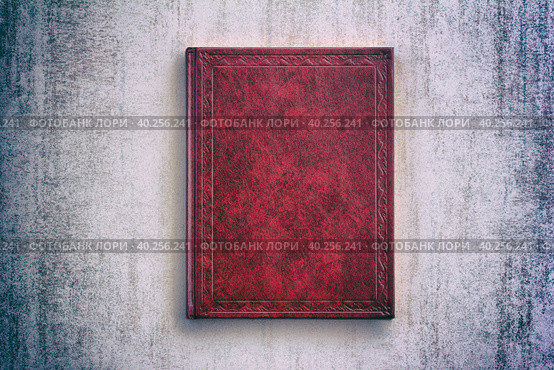 The book in a red cover over gray grunge background, top view with vignette. Стоковое фото, фотограф Андрей С / Фотобанк Лори