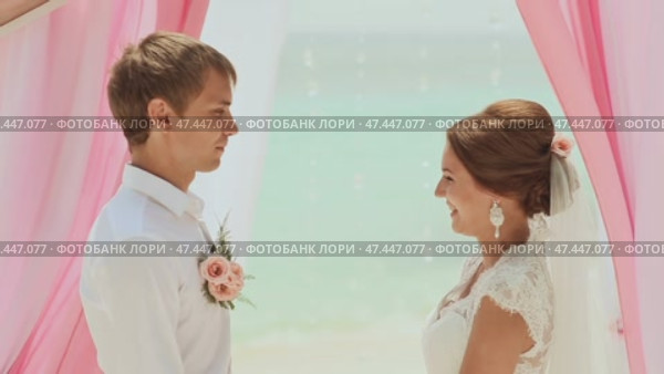 The bride and the bridegroom swear an oath to each other. Wedding ceremony at the beach of the Philippines. Стоковое видео, видеограф Mikhail Davidovich / Фотобанк Лори