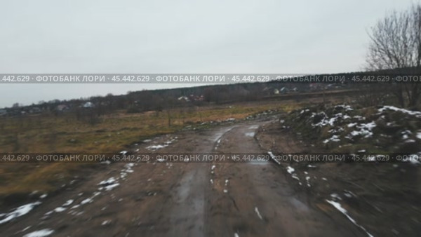 The camera descends from a height on a rural country road dusted with the first snow and flies over it at high speed. Aerial photography from a drone. Стоковое видео, видеограф Ярославский Максим / Фотобанк Лори