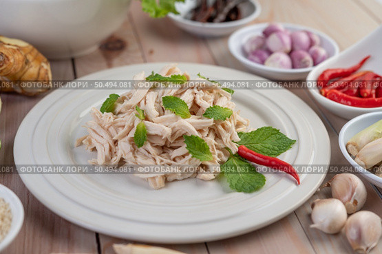 The chicken that is bordered is cooked and placed in a white plate along with mint leaves. Стоковое фото, агентство Ingram Publishing / Фотобанк Лори