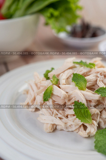 The chicken that is bordered is cooked and placed in a white plate along with mint leaves. Стоковое фото, агентство Ingram Publishing / Фотобанк Лори