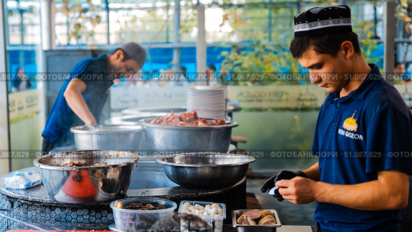 The concept of oriental cuisine. Assorted Uzbek food set, pilaf, samsa, lagman, manta, shurpa central asia food. Homemade Uzbek pilaf or plov from lamb served in cast iron cookware. Стоковое фото, фотограф Feruza Tashmetova / Фотобанк Лори