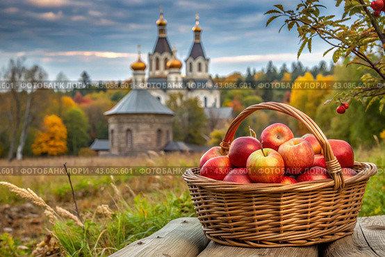 The concept of the Russian Orthodox holiday yablochny spas. A beautiful wicker basket made of vines with red ripe apples on the background of an Orthodox church. Стоковое AI-изображение, AI-художник Photojuli / Фотобанк Лори