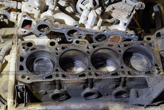 The cylinder block of the four-cylinder engine. Disassembled motor vehicle for repair. Parts in engine oil. Car engine repair in the service. Стоковое фото, фотограф Леонид Еремейчук / Фотобанк Лори