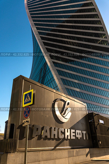 The emblem of the Transneft company on the background of the Evolution tower against the blue sky. Moscow City. Russia. Moscow. Krasnopresnenskaya embankment. 03.03.2024. Редакционное фото, фотограф Ярославский Максим / Фотобанк Лори