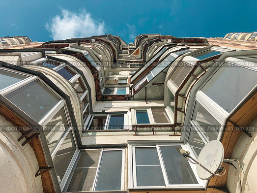 The facade of a modern residential multi-storey building against a clear blue sky. The concept of residential real estate. Стоковое фото, фотограф Ярославский Максим / Фотобанк Лори