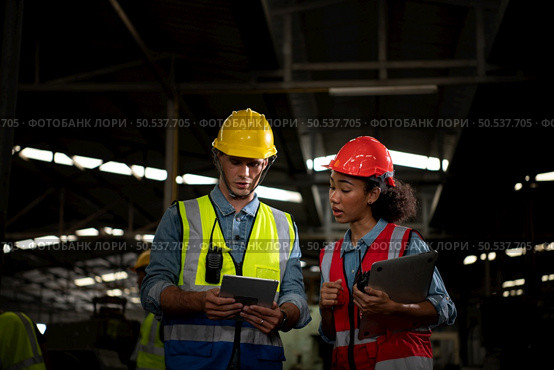 The foreign chief engineer came to inspect the old mechanical factory. There is an African female mechanic explaining details and progress reports on old machines being repaired to restore normal operation. Стоковое фото, агентство Ingram Publishing / Фотобанк Лори