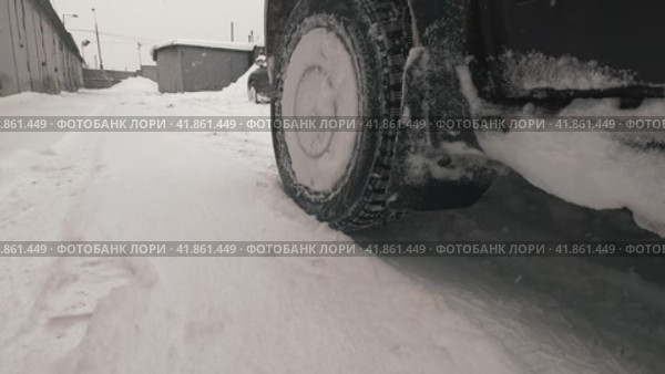 The front wheel with winter studded tires starts abruptly in front of the camera on a slippery road. Стоковое видео, видеограф Ярославский Максим / Фотобанк Лори