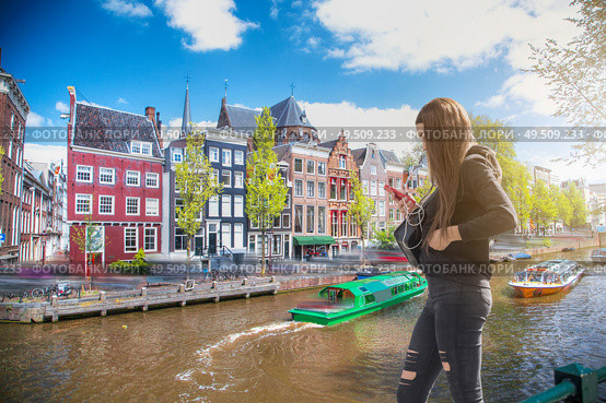 The girl listens to music and walks around Amsterdam. Стоковое фото, агентство Ingram Publishing / Фотобанк Лори
