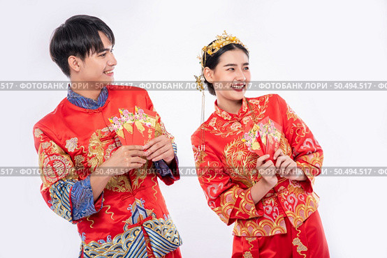 The Man and woman wear cheongsam glad to get the gift money from their relative in traditional day. Стоковое фото, агентство Ingram Publishing / Фотобанк Лори